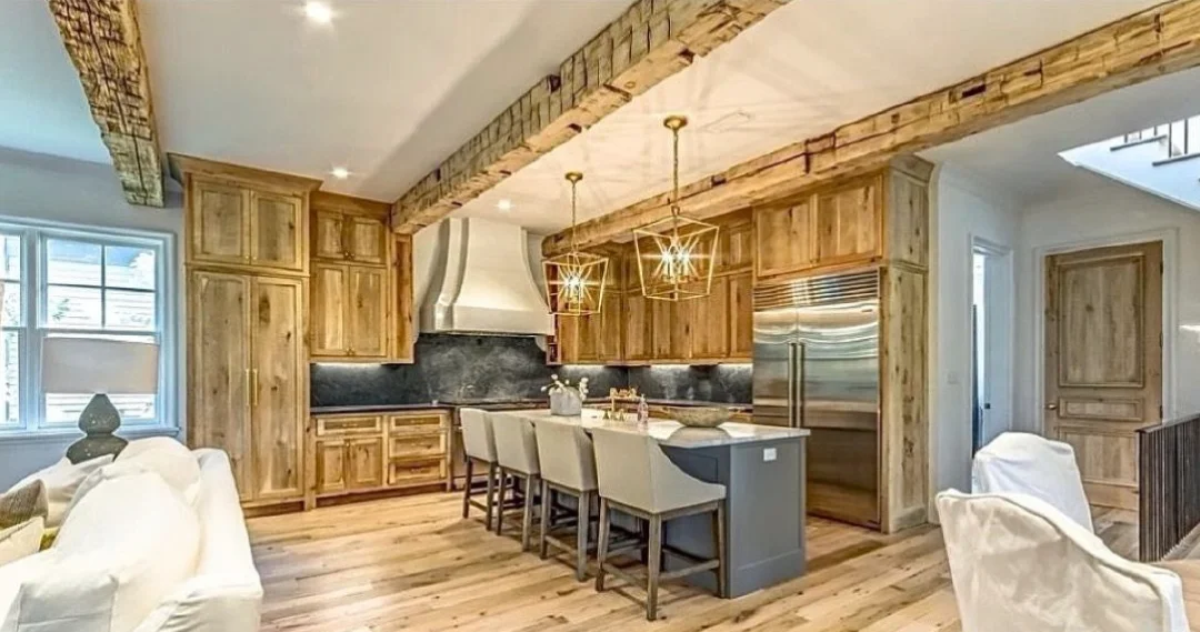 A kitchen with wood beams and wood floors.