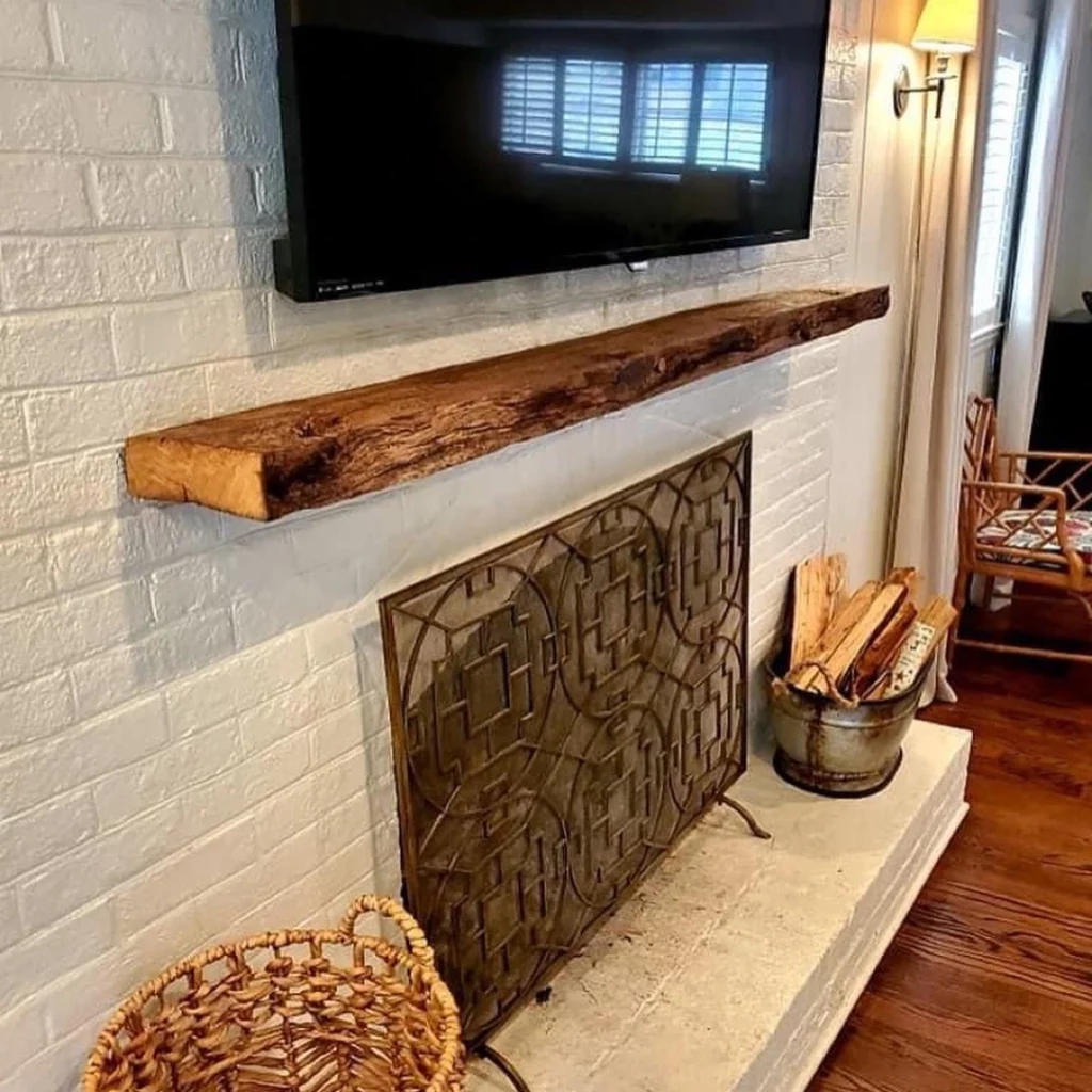 A fireplace with a TV and a wooden shelf on top of it.