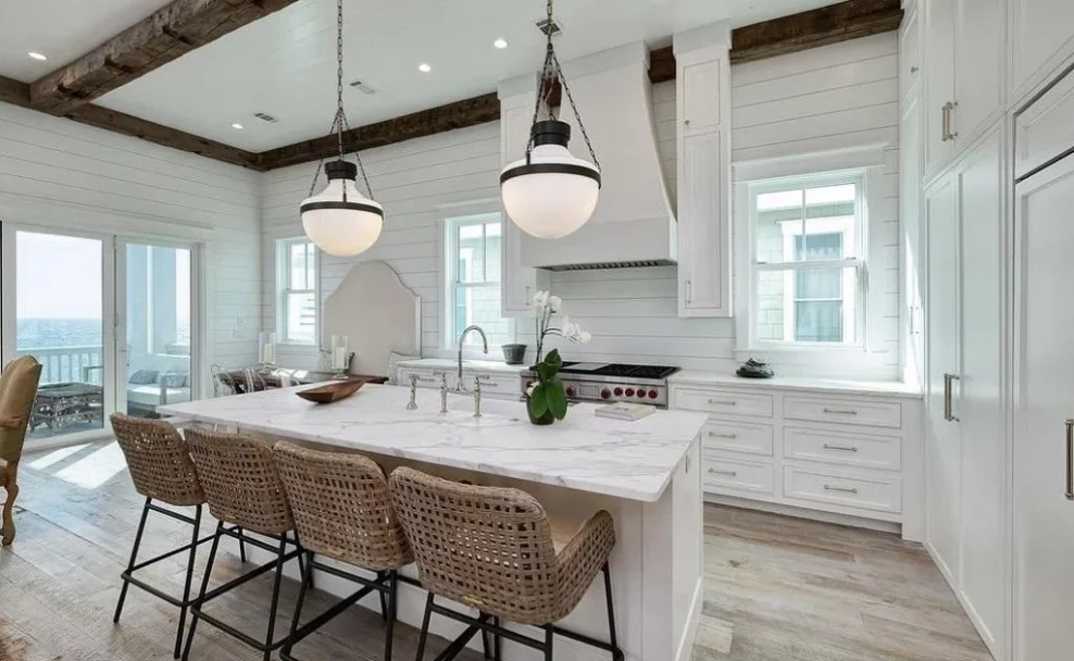 A white kitchen with wooden beams .
