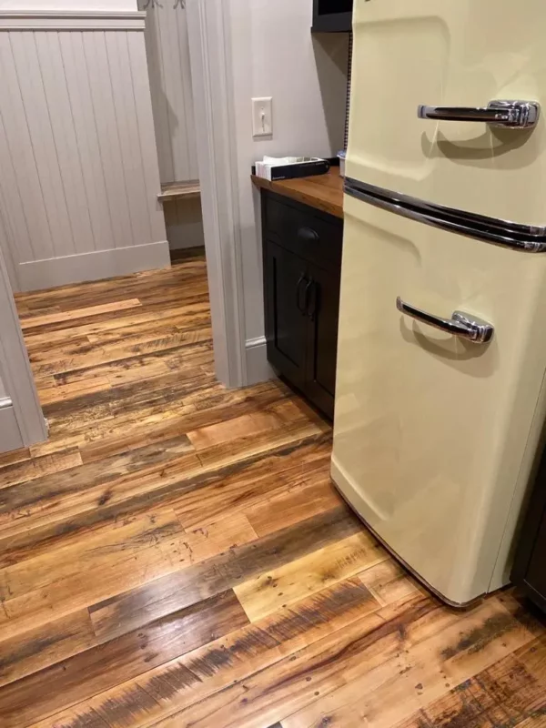 A refrigerator in a kitchen with edgefield mixed hardwoods floor.