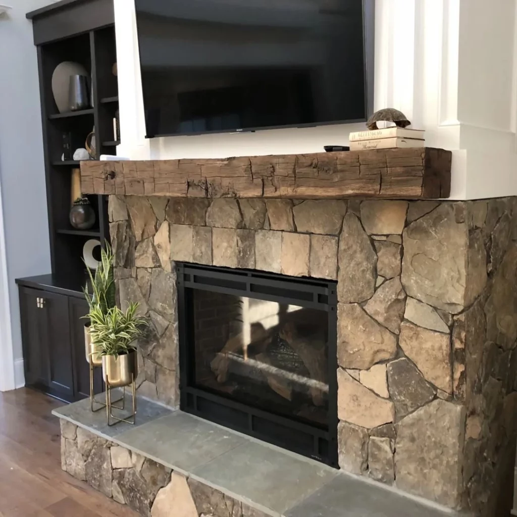 A fireplace mantle with a tv above it.