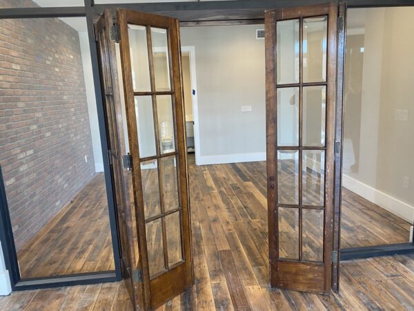 A glass door in a room with mixed hardwoods floor.