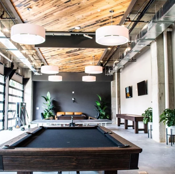 A large room with a billard table and a wooden roof in it.