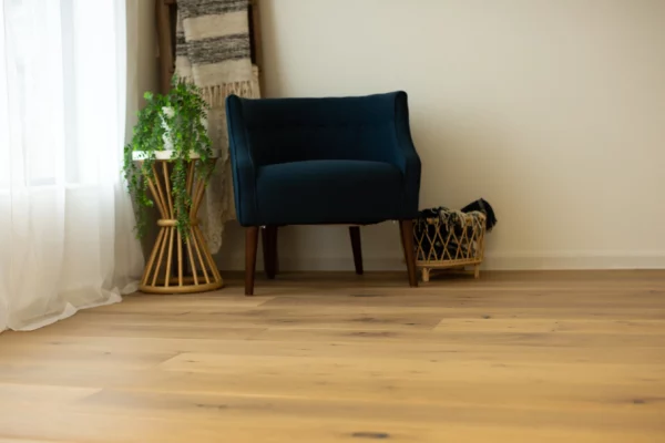 A blue sofa in a room corner is put on engineered European oak flooring.